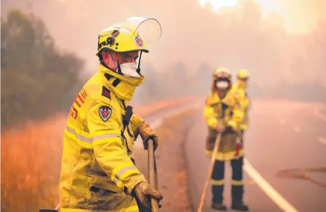  ?? Picture: JANE DEMPSTER/THE AUSTRALIAN ?? NSW Fire and Rescue volunteers battle a blaze on the Pacific Highway which was closed south of Taree. Australia is one of the very few countries in the world that can rely on volunteers for emergency services