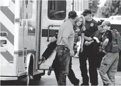  ?? The Eastern New Mexico News via Associated Press ?? n An injured woman is carried to an ambulance Monday in Clovis, N.M., as authoritie­s respond to reports of a shooting inside a public library.