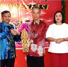  ??  ?? (From left) Edward presents a replica of a Dayak warrior’s shield to Penguang as a memento, witnessed by MDC secretary Lolita Jaime Nicholas Buyok.