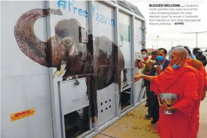  ??  ?? BLESSED WELCOME ... A Buddhist monk sprinkles holy water around the crate containing Kaavan the Asian elephant upon his arrival in Cambodia from Pakistan at Siem Reap Internatio­nal Airport yesterday. – AFPPIX