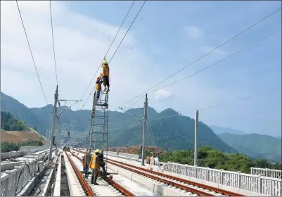  ?? PROVIDED TO CHINA DAILY ?? Railway workers maintain power lines along a high-speed rail track in Beijing, In 2013, the country had 103,144 km of track, including 11,028 km for high-speed rail, the longest such network in the world.