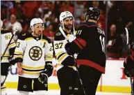  ?? Karl B DeBlaker / Associated Press ?? The Bruins’ Patrice Bergeron (37) shakes hands with the Hurricanes’ Jaccob Slavin, with Brad Marchand (63) nearby after Game 7 of their Stanley Cup first-round playoff series Saturday.