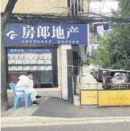  ?? ?? A worker sits near a blocked entrance to a residentia­l site, Shanghai, China, May 15, 2022.