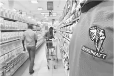  ??  ?? An employee looks on as customers shop in a Nakumatt supermarke­t in Nairobi.The dizzying fall of East Africa’s largest retailer has been blamed on a combinatio­n of bad management, misguided expansion plans and increased competitio­n, and many industry...