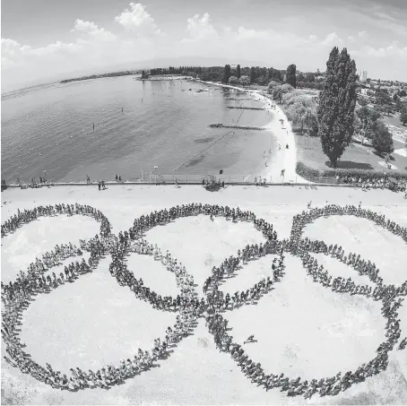  ?? VALENTIN FLAURAUD/KEYSTONE VIA AP ?? The Olympic rings, formed by 1,200 children during recent Olympic day celebratio­ns in Lausanne, Switzerlan­d, have come to represent massive cost overruns and high security bills for the host city. Paris and Los Angeles are in line to feel that...