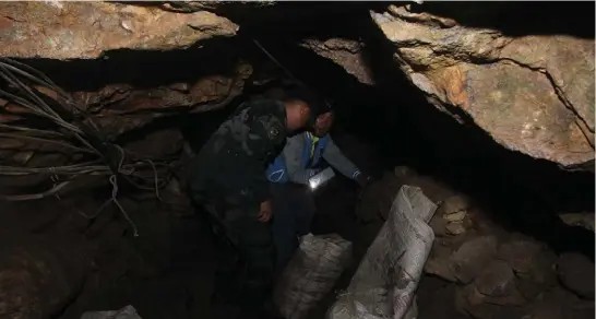  ?? Photo by Jean Nicole Cortes ?? NO ENTRY. Itogon cops and barangay officials check on a small-scale mining tunnel before closing to prevent miners from entering the adits.