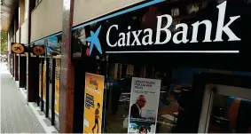  ??  ?? «Adiòs» Catalogna Un’agenzia di CaixaBank nel centro di Barcellona (Reuters)