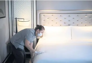  ?? REUTERS ?? A hotel worker cleans a bed as a precaution against Covid-19 at a Bangkok hotel. Hotel operators that are applying for a hotel business licence are allowed to apply for the soft loan scheme.