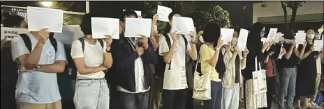  ?? ASSOCIATED PRESS ?? Protesters hold up blank, white papers, Monday, at the Chinese University of Hong Kong in Hong Kong, during a commemorat­ion for victims of a recent Urumqi deadly fire.