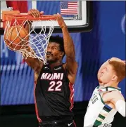  ?? MARK J. TERRILL / ASSOCIATED PRESS ?? The Miami Heat’s Jimmy Butler dunks Monday night in Lake Buena Vista, Fla., after getting past Milwaukee’s Donte DiVincenzo during the second half of Game 1 in the Eastern Conference semifinals. Miami pulled away late for a 115-104 victory.