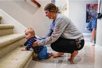  ?? ?? Nanny Hannah Thurman helps Lucy up the stairs at her home in Danville. Lucy has been getting some form of therapy since she was 6 months old and fell behind on developmen­tal milestones.