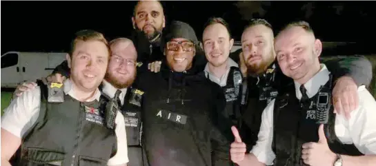  ??  ?? All Wright on the night: Six Metropolit­an Police officers pose with Ian Wright for a selfie after finding his stolen car