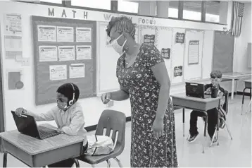  ?? MIKE STOCKER/SOUTH FLORIDA SUN SENTINEL ?? Second grader Claude Poucely gets instructio­n from teacher Tiffany Harmon last October at Broward Estates Elementary School in Lauderhill.