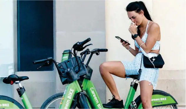  ?? Kamal Kassim/gulf Today ?? ↑ This resident measures her fitness specificat­ions on her mobile phone.