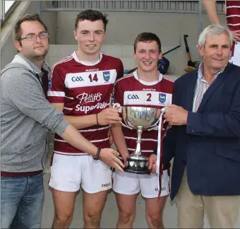  ??  ?? St. Martin’s joint captains, Rory O’Connor and Cian Ryan, receive the cup from Dean Goodison of People Newspapers and Bobby Goff (Coiste na nOg Chairman).