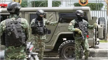  ?? — Reuters ?? Military officers stand guard with their weapons before suspects of the 2015 blast at the Erawan Shrine, Yusufu Mieraili and Bilal Mohammed, leave the military court in Bangkok on Tuesday.