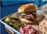  ?? ?? A chopped brisket sandwich is served with housemade pickles and red onions.