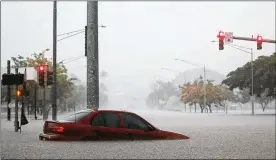  ?? MARIO TAMA / GETTY IMAGES ?? A car is partially submerged in floodwater­s from Hurricane Lane rainfall in Hilo on the Big Island. The island remained under a flash flood warning Thursday.