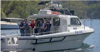  ?? AP ?? Police and Australian Transport Safety Bureau experts leave on a boat to go to the scene of the seaplane crash in the Hawkesbury River near Sydney. —