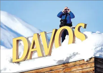  ?? FABRICE COFFRINI/AFP ?? Swiss armed security personnel stand guard on the rooftop of a hotel near the Congress Centre on Wednesday in Davos, eastern Switzerlan­d.
