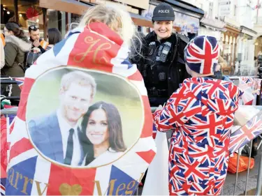  ?? PICTURE: REUTERS ?? WEDDING BELLS: A police officer chats to fans of Britain’s royal family in Windsor yesterday. The wedding of Prince Harry and Meghan Markle is due to take place tomorrow at Windsor Castle.