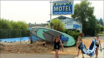  ?? JOE FRIES/Penticton Herald ?? Fun-seekers pass by the ill-fated Ogopogo Motel on Thursday.