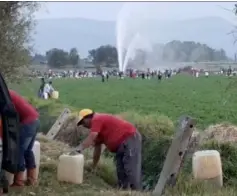  ??  ?? TRAGIC: People collect fuel as the pipe spews petrol