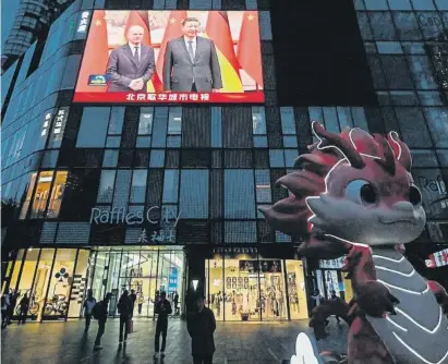  ?? PEDRO PARDO / AFP ?? Una pantalla muestra al alemán Olaf Scholz y al chino Xi Jinping ayer en una calle de Pekín