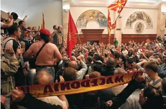  ?? PHOTO: BORIS GRDANOSKI/AP ?? FIERY SCENES: After breaking through a police cordon, protesters enter the parliament building in Skopje to protest the election of a new speaker.