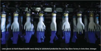  ?? BLOOMBERG ?? Latex gloves on hand-shaped moulds move along an automated production line at a Top Glove factory in Setia Alam, Selangor