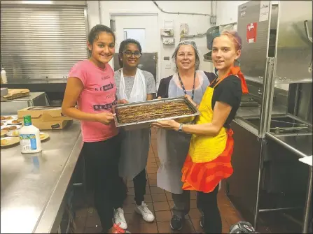  ?? (Courtesy Photo/Abode Services) ?? Jawa (from left), Anika Garikipati, Monica Quintana and Caitlin Starmer pose with freshly baked desserts inside the Abode Services homeless shelter in Fremont.