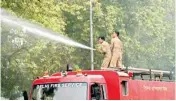  ?? PIC/MPOST ?? Fire personnel spray water on trees to prevent dust pollution in Delhi on Saturday