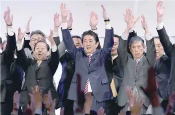  ?? — AFP ?? Prime Minister and ruling Liberal Democratic Party leader Shinzo Abe (C) leads ‘Banzai’ shouts at the end of his party convention in Tokyo on Sunday.