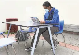  ?? Yalonda M. James / The Chronicle ?? Andrew Taate, a freshman, works at a desk in a courtyard at Thurgood Marshall High School in San Francisco. Teachers meet with students outside the school on Wednesdays to provide them with a range of support.