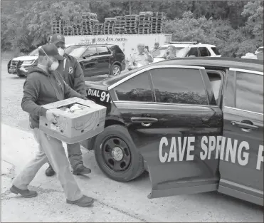  ?? Doug Walker ?? Deputy Jeff Black puts a load of food into the back of a Cave Spring police cruiser for delivery to an elderly resident. Cpl. Tony Boston at the FCSO, who also serves part-time with the Cave Spring Police Department, made the delivery on Thursday.