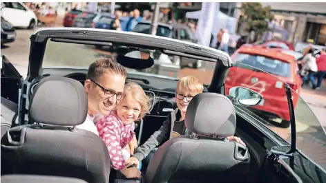  ?? RP-FOTO: RALPH MATZERATH ?? Autoschau in Hilden: Sven Sieger mit Marie und Philipp haben probehalbe­r in einem Cabrio Platz genommen.