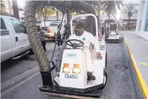  ?? C.M. GUERRERO/EL NUEVO HERALD/AP ?? A Miami Beach worker on Friday gets ready to clean the alleyways of South Beach, sucking up still water and debris with a mobile vacuum as part of the city’s Zika cleanup.