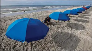  ?? (AP Images for Visit Myrtle Beach/Mic Smith) ?? Socially distanced umbrellas offer shade July 30 along the coastline in Myrtle Beach.