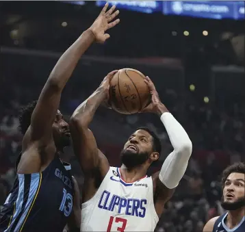  ?? MARK J. TERRILL — THE ASSOCIATED PRESS ?? The Clippers’ Paul George, center, shoots as Memphis’ Jaren Jackson Jr., left, defends during Sunday night’s victory.