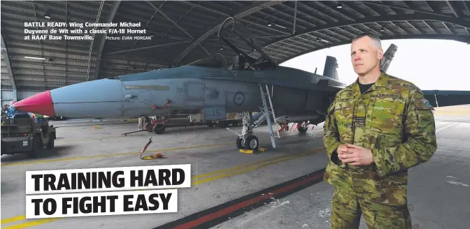  ?? Picture: EVAN MORGAN ?? BATTLE READY: Wing Commander Michael Duyvene de Wit with a classic F/ A- 18 Hornet at RAAF Base Townsville.