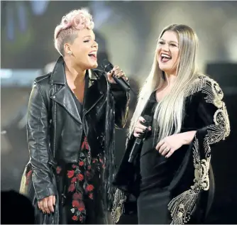  ?? MATT SAYLES/ INVISION/AP ?? Pink, left, and Kelly Clarkson perform Everybody Hurts at the American Music Awards on Sunday in Los Angeles. The pair kicked off the event with a performanc­e honouring those affected by tragic events of the year.