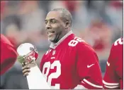  ?? (JIM GENSHEIMER — BAY AREA NEWS GROUP, FILE ?? Former San Francisco 49ers wide receiver John Taylor holds the 1988 Super Bowl trophy during a 2015 halftime ceremony at Levi’s Stadium in Santa Clara.