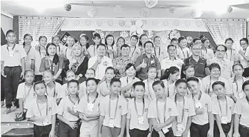  ??  ?? Dennis (seated third row, fourth right) joins local officials and community leaders in a group photo with the primary school-children.