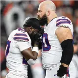  ?? DYLAN BUELL / GETTY IMAGES ?? Tre’Davious White (left) and Mitch Morse of the Buffalo
Bills react to teammate Damar Hamlin collapsing after making a tackle against the Bengals at Paycor Stadium on Monday in Cincinnati.