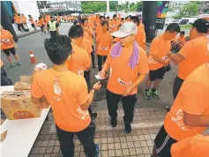  ??  ?? One of the runners hands over his tag to the event volunteer to redeem his gift.