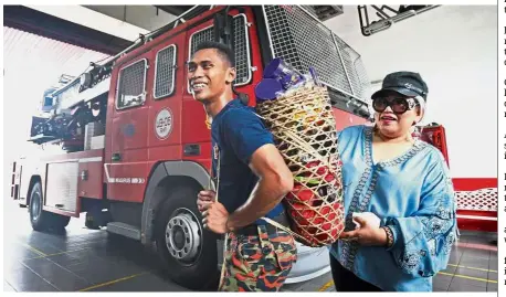  ??  ?? Token of appreciati­on: Siti presenting the chocolates to a fireman at the Sri Hartamas Fire and Rescue Station in Kuala Lumpur.