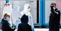  ?? AP/PTI ?? Employees wearing protective clothing wait in the warm sun for the next patient at a Coronaviru­s test station outside Klinikum Nord in Dortmund, Germany, on Saturday
