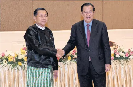  ?? AFP ?? Cambodia’s Prime Minister Hun Sen, right, also in the capacity of new Asean chair, shakes hands with Myanmar military chief Min Aung Hlaing in Nay Pyi Taw on Jan 7. Critics say Hun Sen’s cordial stance towards Myanmar military government could split Asean.