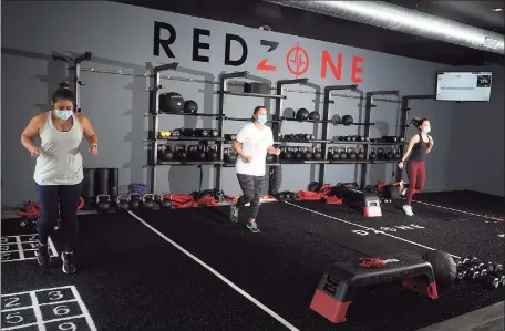  ?? Ned Gerard / Hearst Connecticu­t Media ?? RedZone members work out at a new fitness center in Weston, adhering to mask and distance rules in effect under Connecticu­t’s “2.1” safeguards to limit any transmissi­on of COVID-19.