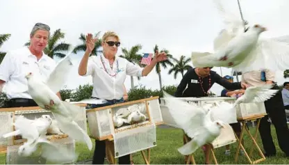  ?? CARLINE JEAN/SOUTH FLORIDA SUN SENTINEL ?? Pompano Beach Mayor Rex Hardin and Commission­er Rhonda Eaton release doves during a Memorial Day observance at the Pompano Beach Cemetery on Monday.